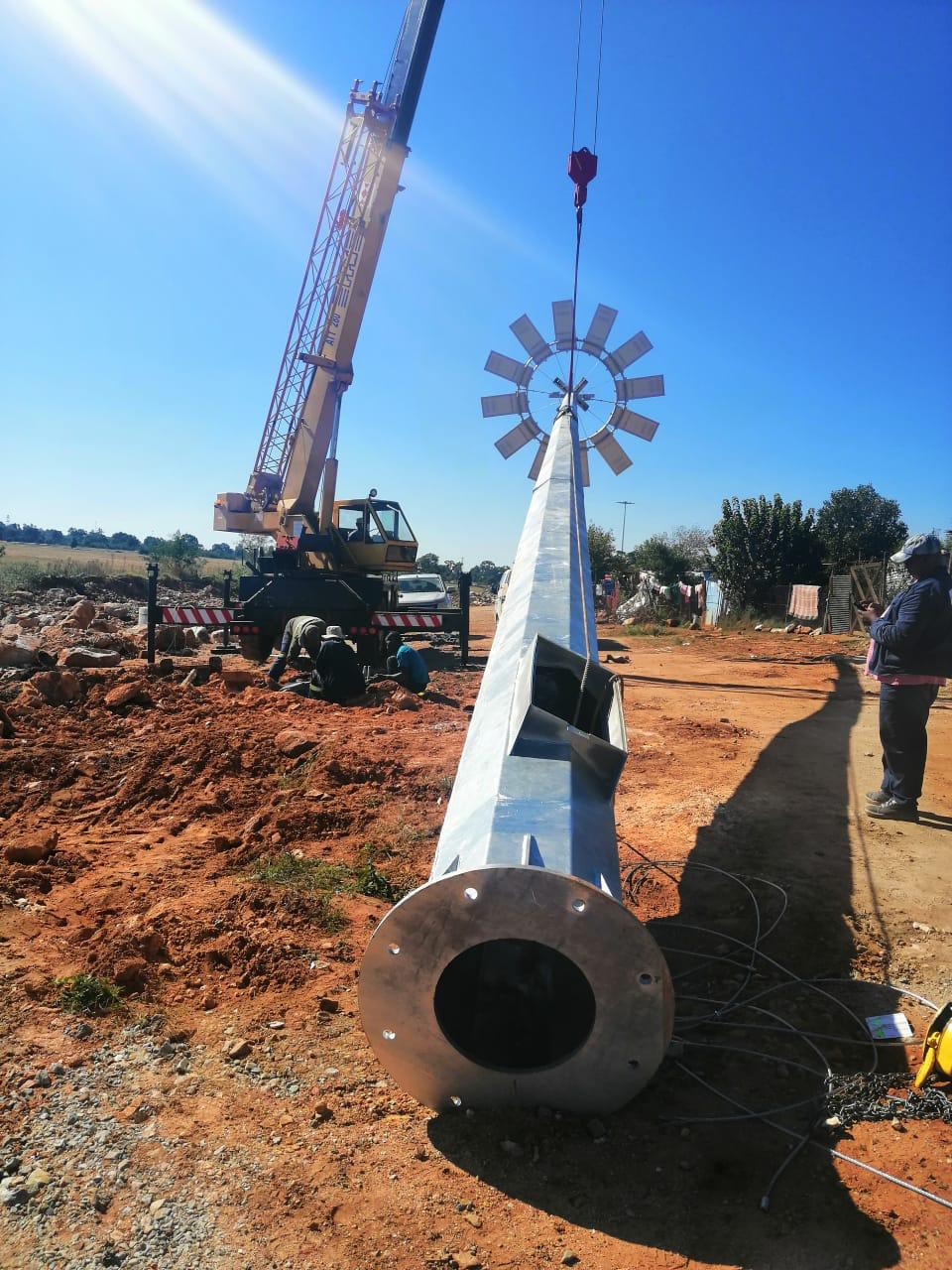 Professional engineers installing a solar mast, highlighting design and installation services.